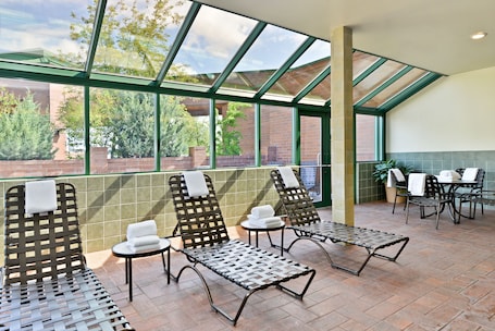 Una piscina techada, sillones reclinables de piscina