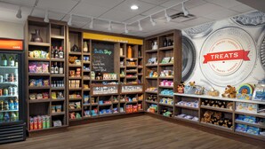 A store with wooden shelves stocked with snacks, drinks, and toys. - Hampton Inn Kalispell (Kalispell)