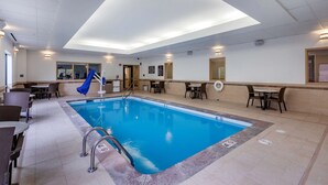 A hotel swimming pool with a blue interior, surrounded by seating areas and a covered outdoor section. - Sleep Inn & Suites Miles City I-94 (Miles City)