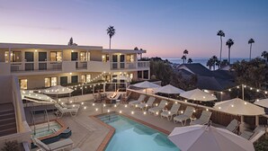 A rooftop pool area with lounge chairs, umbrellas, and string lights. - Laguna Beach House (Laguna Beach)