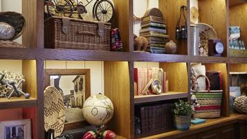 A wooden shelf with various items including a globe, a bicycle, a basket, and books.