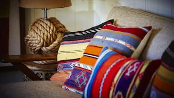 A chair with a woven ball and colorful pillows.