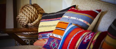 A chair with a woven ball and colorful pillows.