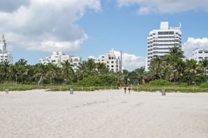 Perto da praia, espreguiçadeiras, guarda-sóis, toalhas de praia 