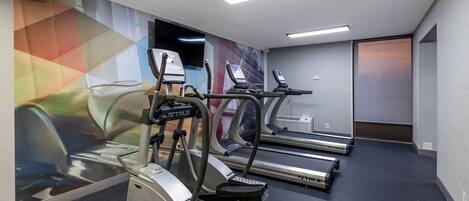 A fitness room with treadmills, a stationary bike, and a stair climber.