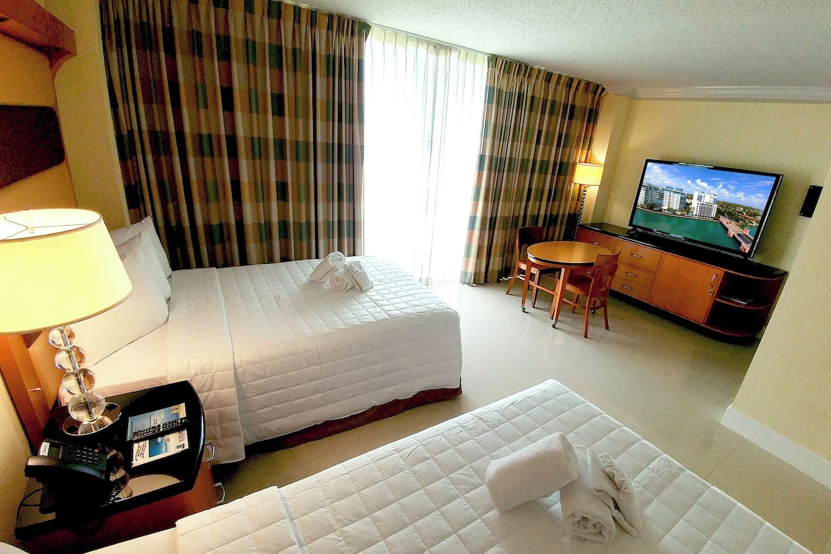 City Room, 2 Double Beds, Partial Sea View | Ylelliset vuodevaatteet, tallelokero huoneessa, työpöytä, pimennysverhot