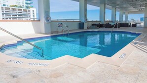 A pool area with clear blue water, a lifeguard chair, and a sign indicating '3FT NODIVING'. - Sixty Sixty Resort (Miami Beach)