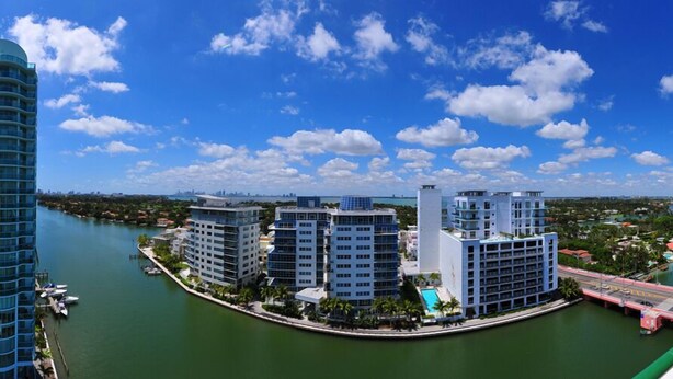 A waterfront hotel with multiple high-rise buildings, a marina, and a clear view of the city skyline. - Sixty Sixty Resort (Miami Beach)
