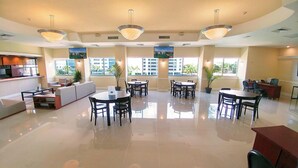 A spacious hotel lobby with multiple seating areas, large windows, and ceiling lights. - Sixty Sixty Resort (Miami Beach)