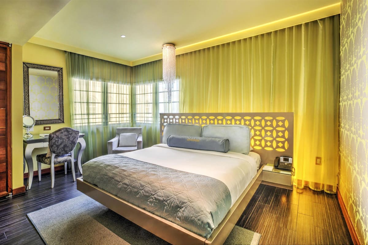 A spacious bedroom with a large bed, a desk, and a chair.