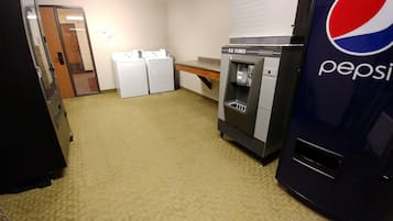 A kitchen with a refrigerator, a water dispenser, and a vending machine.