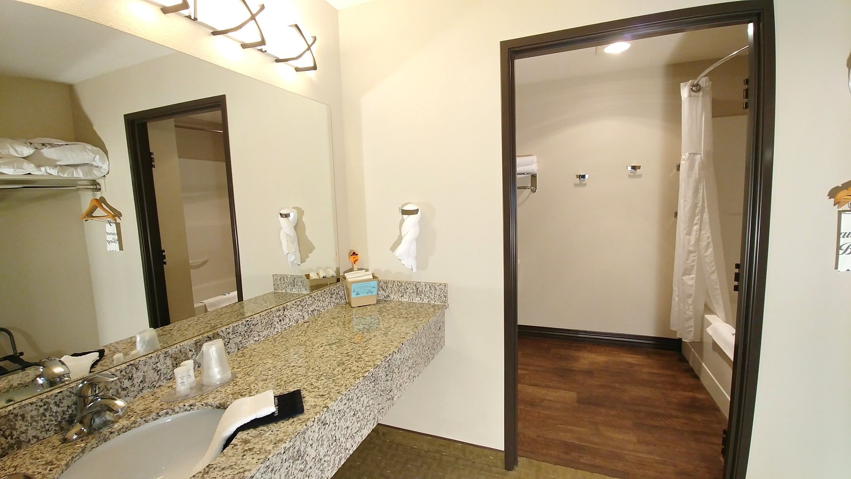 A bathroom with a granite countertop, a sink, a mirror, and a towel rack.