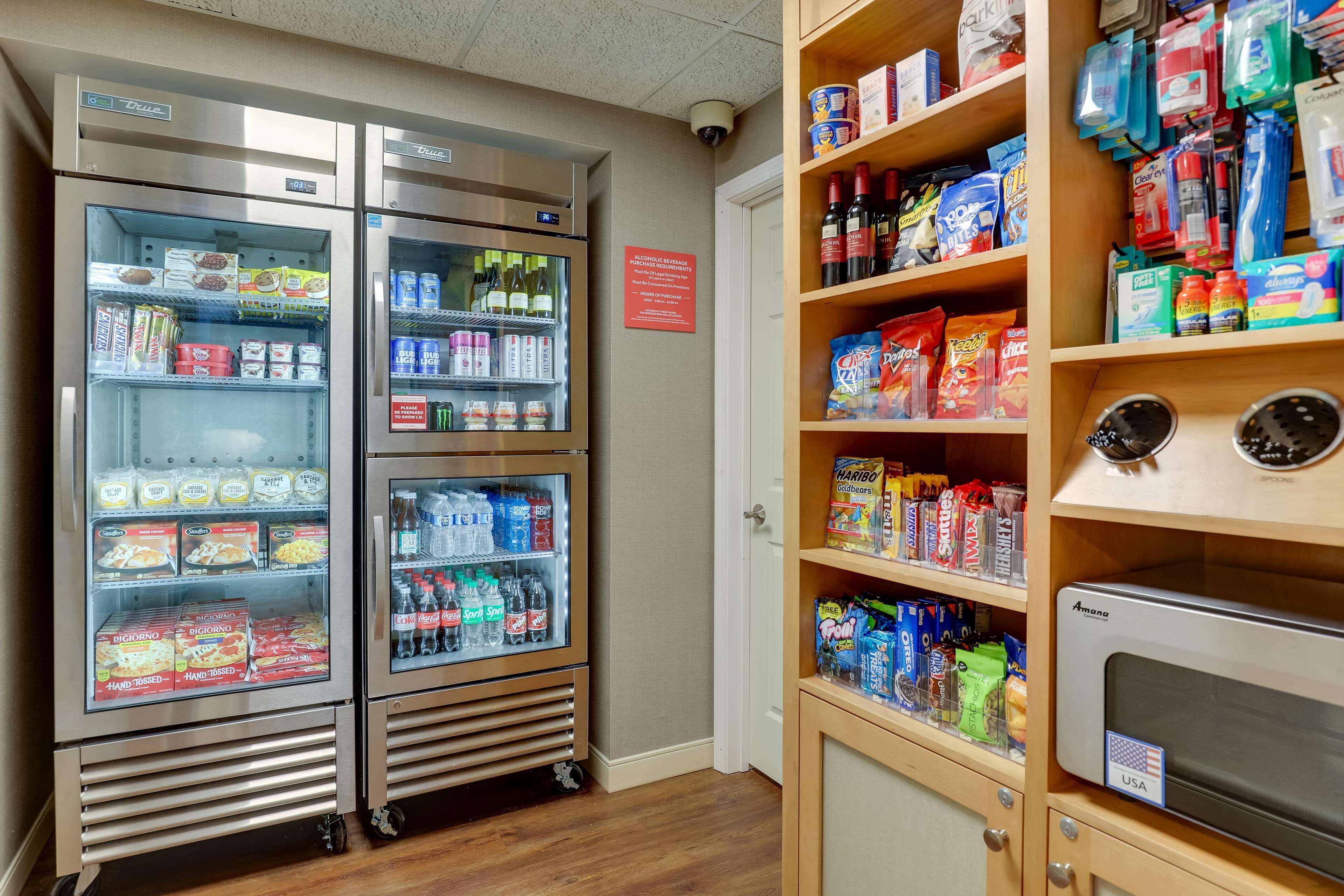 A vending area with refrigerated freezers stocked with snacks and drinks, and shelves with various packaged goods.
