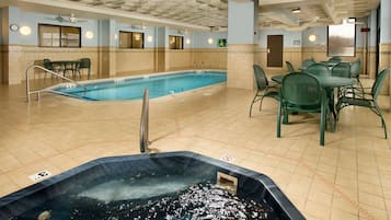 Relax by the pool, surrounded by comfortable seating and a hot tub.
