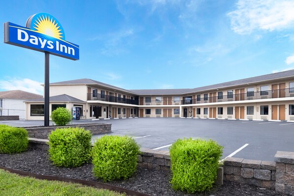 Un hôtel Days Inn doté d’un grand parking, d’une cour intérieure et d’une rangée de chambres de motel.