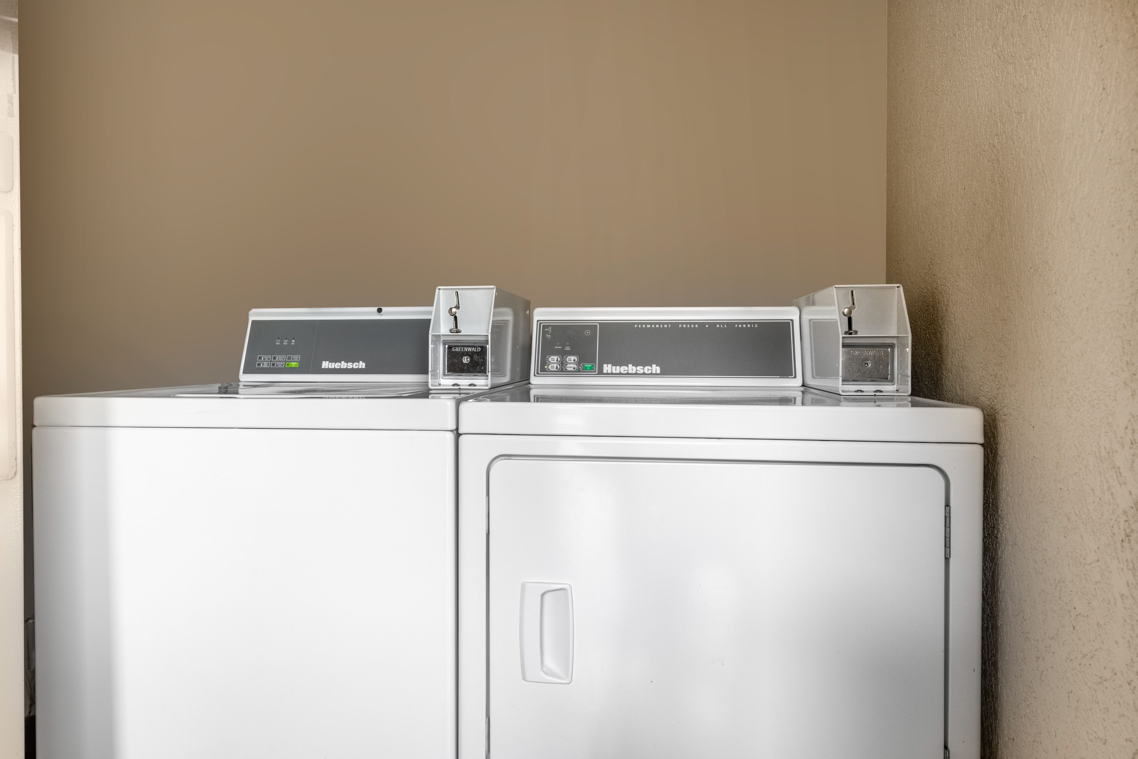 A white washing machine with a control panel and a small device on top.