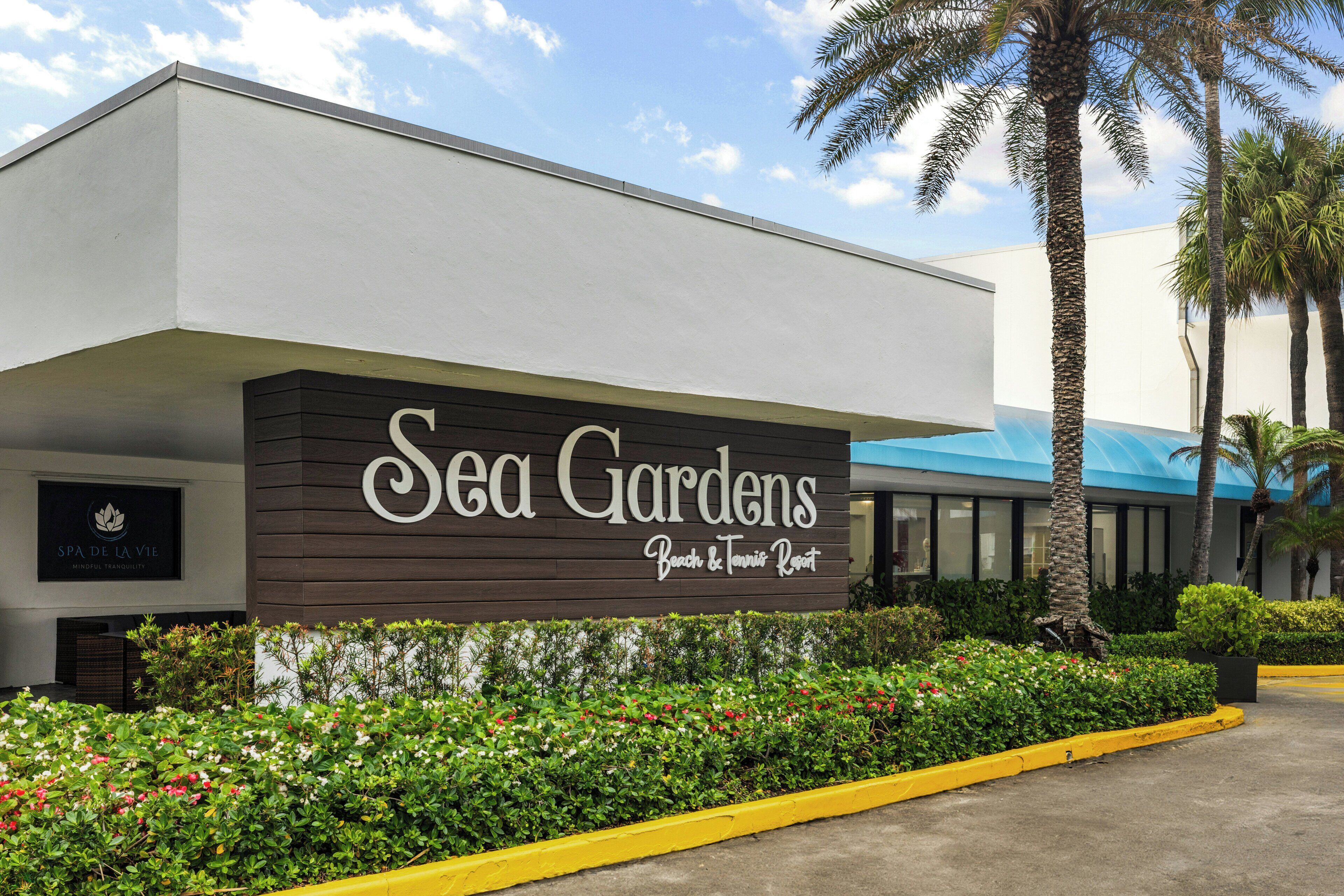 Un edificio con un letrero que dice 'Sea Gardens Beach & Tennis Resort'.