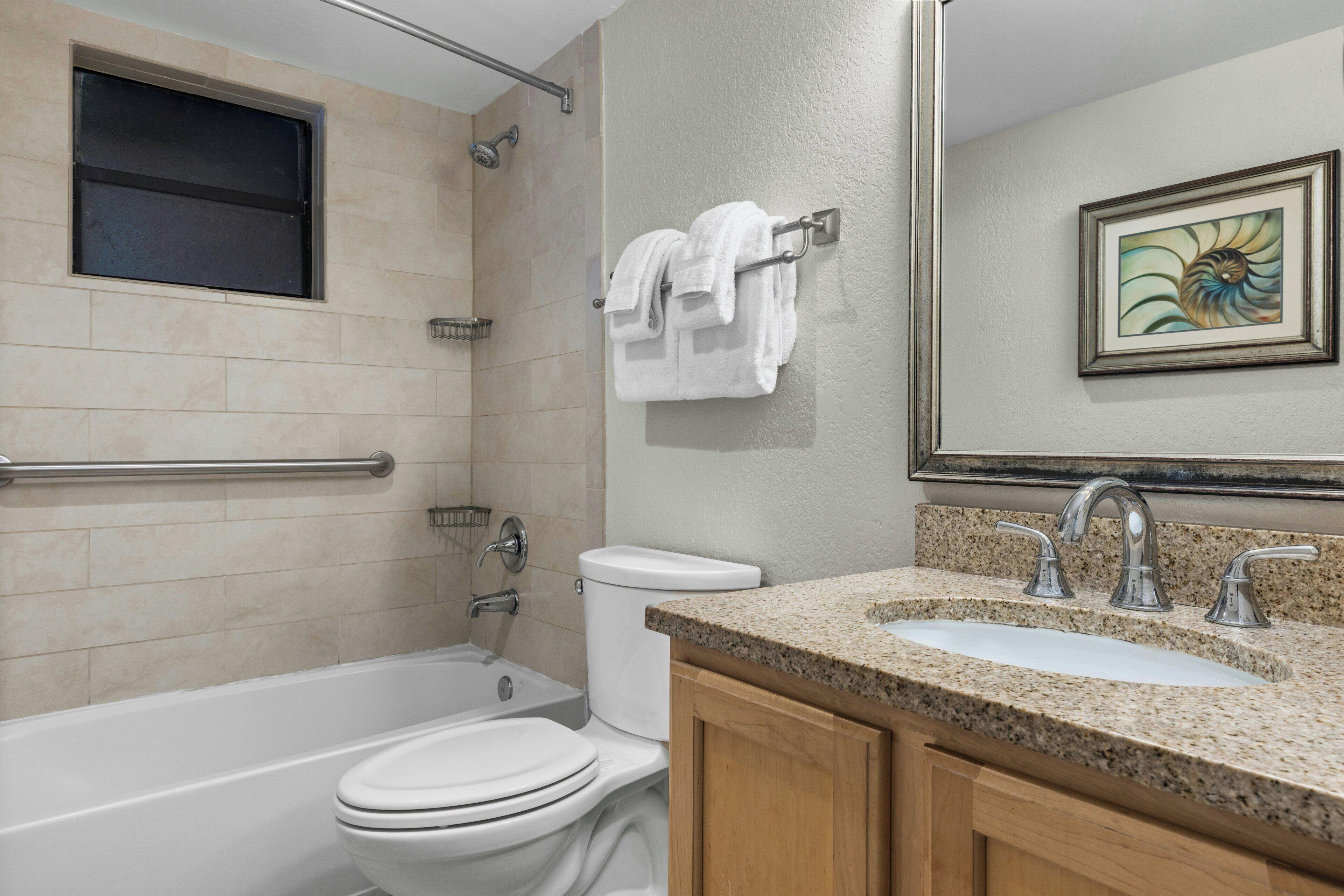 A bathroom with a bathtub, toilet, sink, and a towel rack.