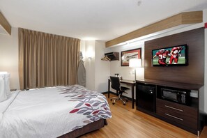A hotel room with a bed, a desk, a television, and a microwave. - Red Roof Inn Pensacola Fairgrounds (Pensacola)