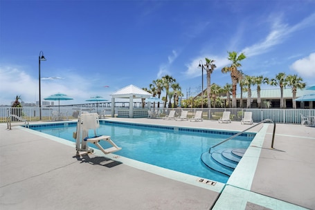 Una piscina al aire libre, sombrillas, sillones reclinables de piscina. Best Western Navarre Waterfront