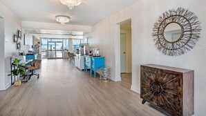 A spacious, well-lit hallway with a modern kitchen area, a dining space, and a decorative mirror on the wall. - Best Western Navarre Waterfront (Navarre)