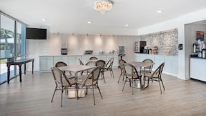 A modern kitchen with a dining area, featuring a large island, built-in appliances, and a unique backsplash. - Best Western Navarre Waterfront (Navarre)