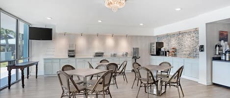 A modern kitchen with a dining area, featuring a large island, built-in appliances, and a unique backsplash.