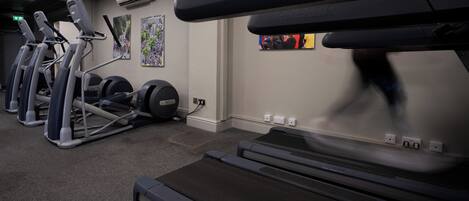 A gym with treadmills, stationary bikes, and weight machines.