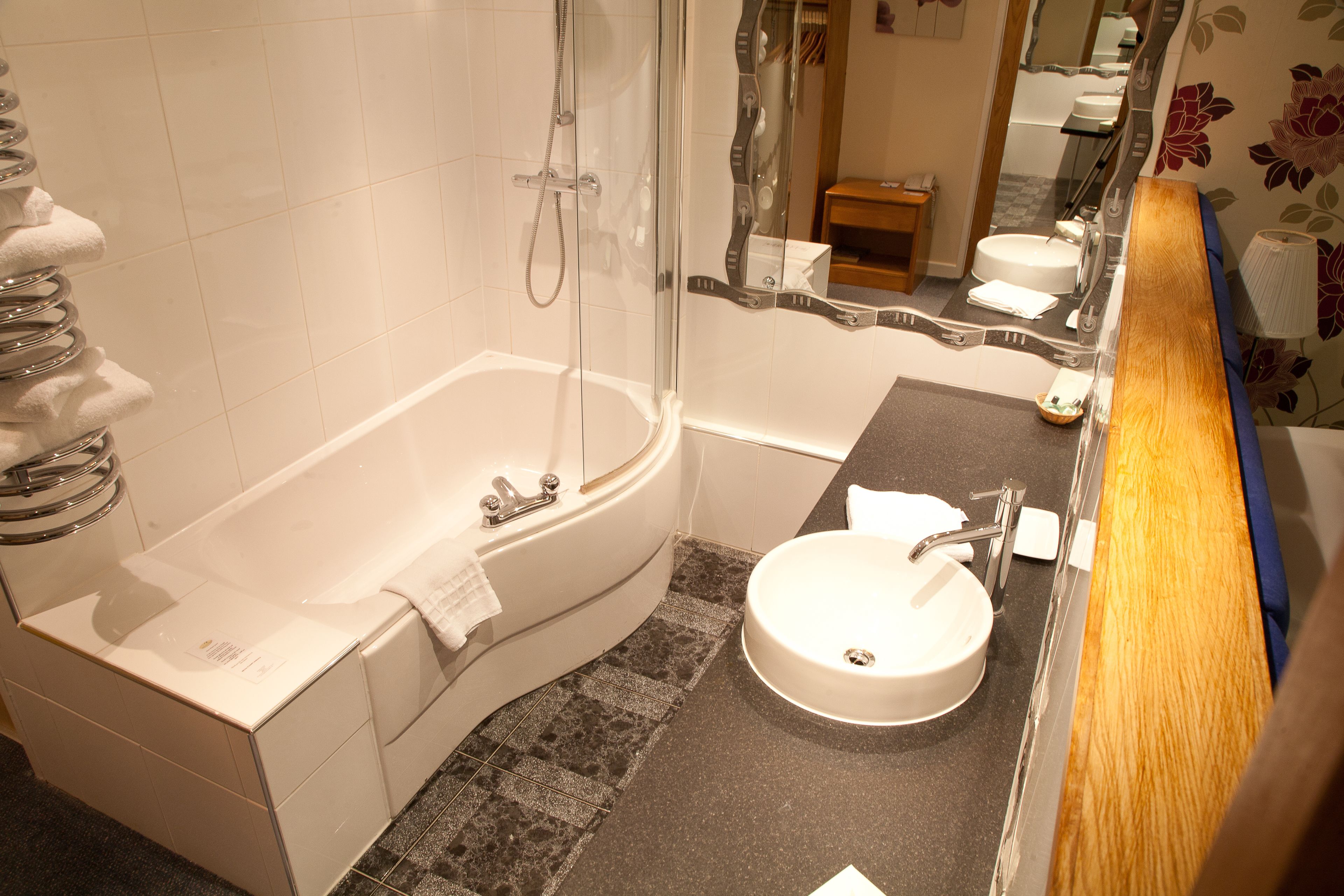 Un baño moderno con bañera, lavamanos y ducha.