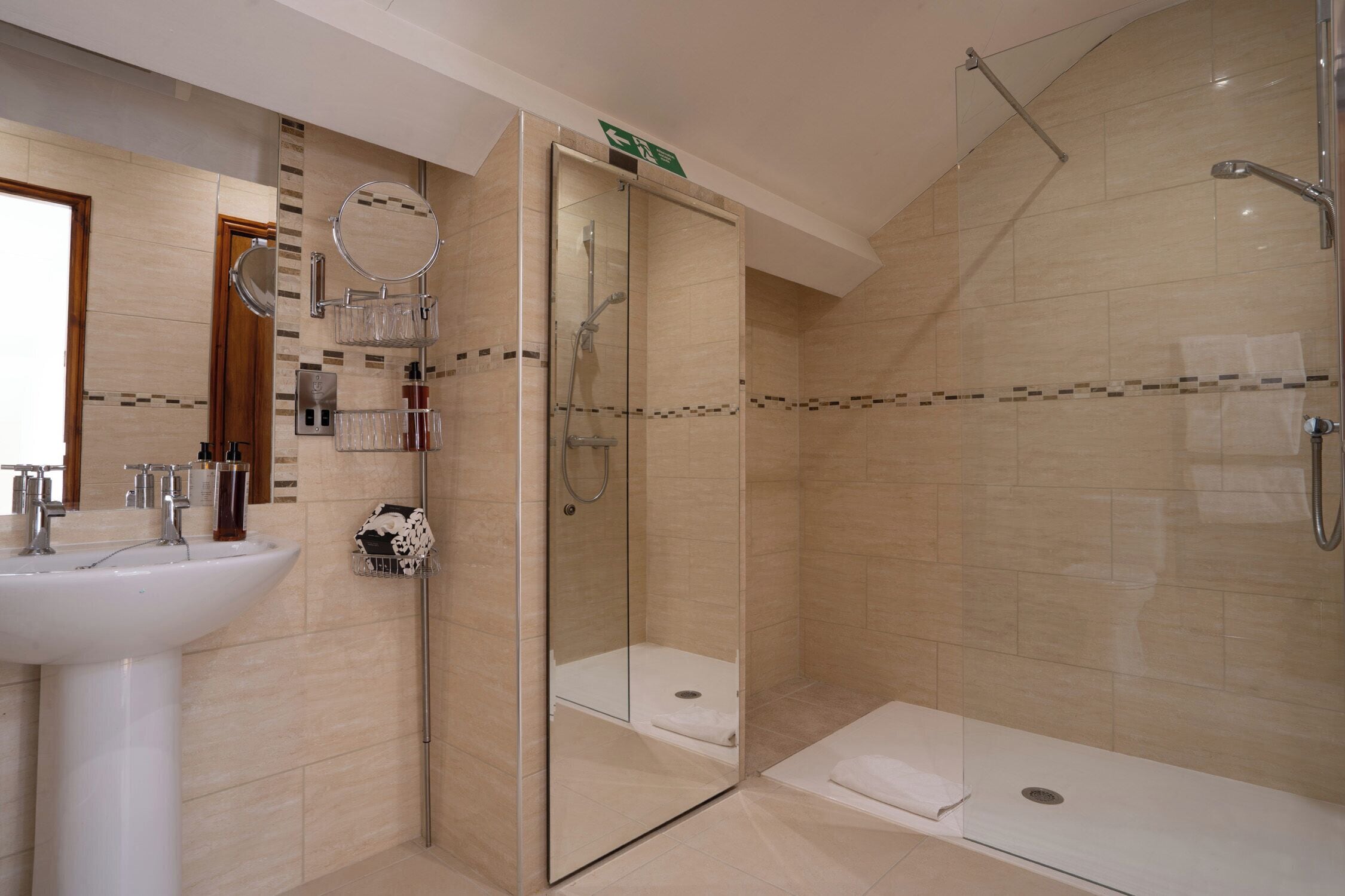 A modern bathroom with a glass-enclosed shower, a sink, and a mirror.