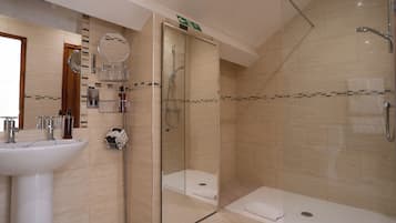 A modern bathroom with a glass-enclosed shower, a sink, and a mirror.
