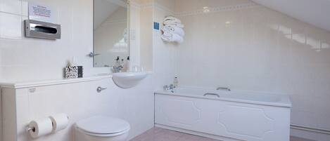A bathroom with a toilet, sink, and bathtub.