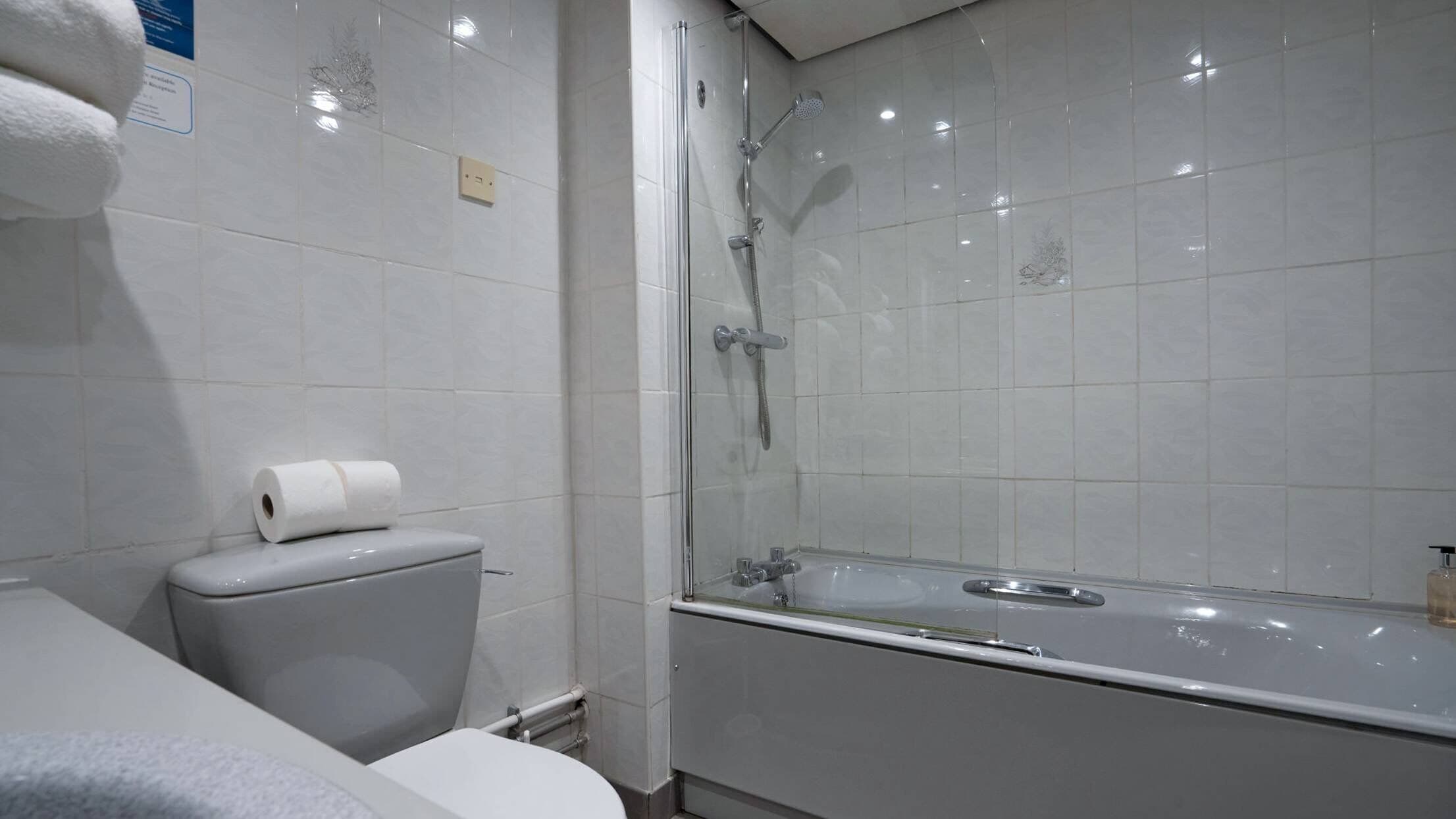 A bathroom with a toilet, a shower, and a bathtub.