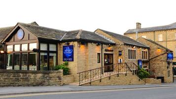 Un edificio de piedra con un letrero que dice 'The Olde Inn' y 'Fish & Chips'.