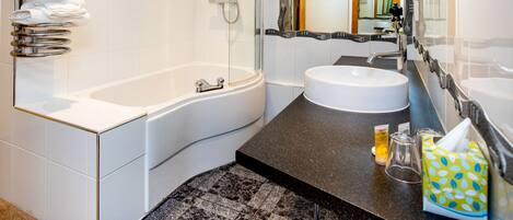A modern bathroom with a bathtub, a sink, and a shower.