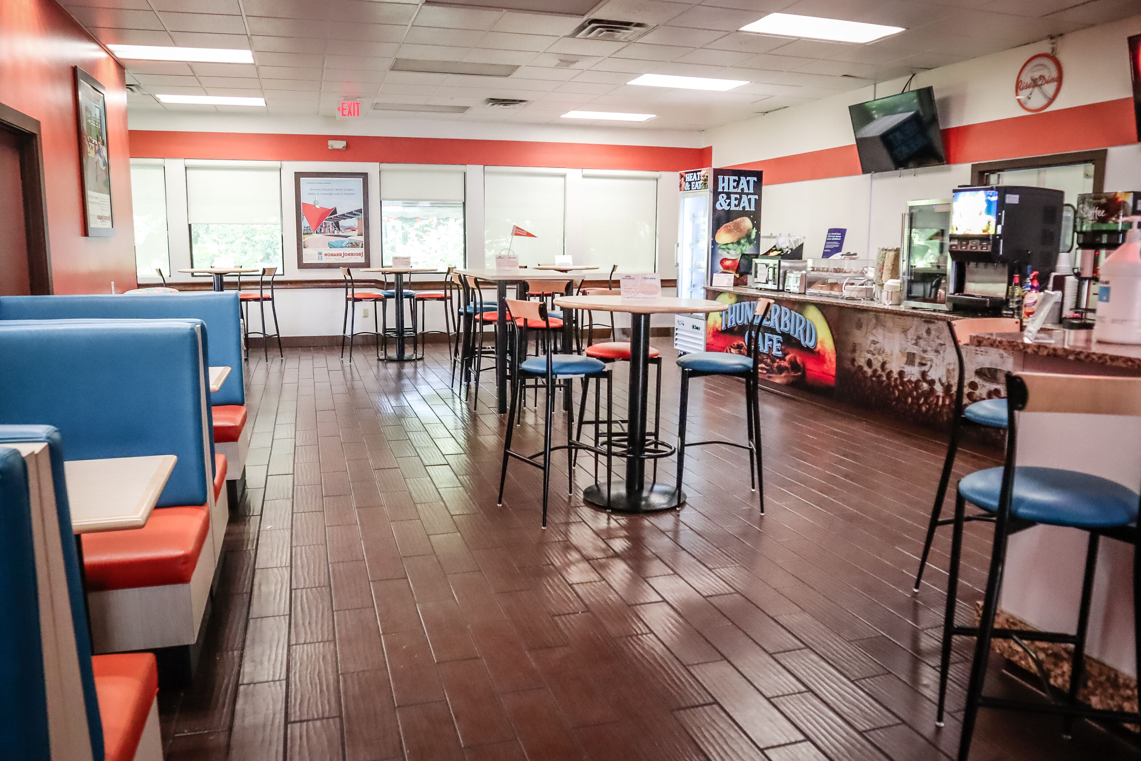 A restaurant interior with booths, tables, and a counter.