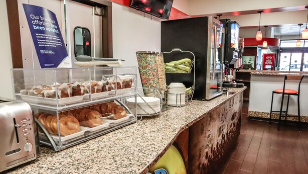 Ein Frühstücksbuffet mit verschiedenen Backwaren und einer Kaffeemaschine.