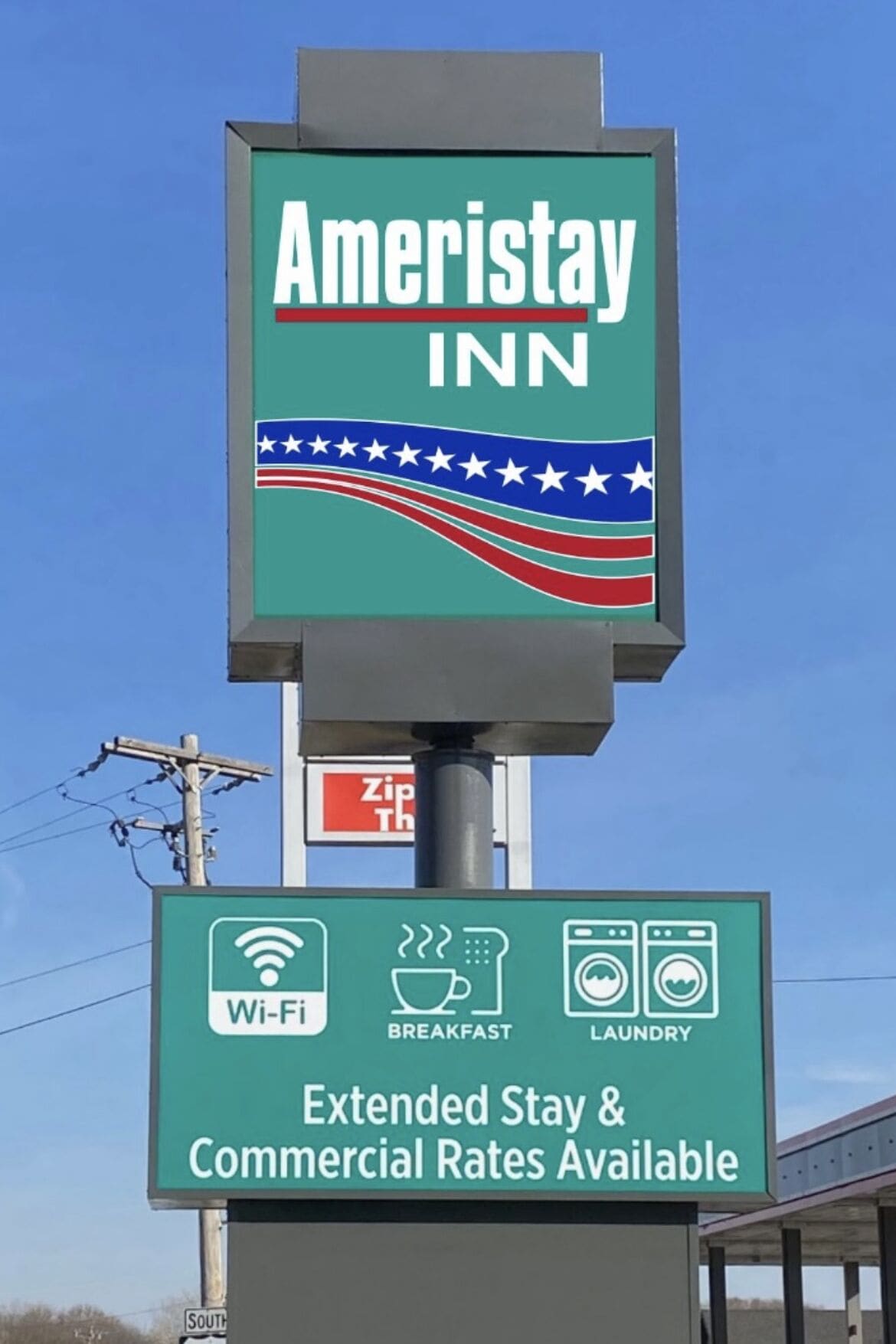 A sign for Ameristay Inn with amenities like Wi-Fi, breakfast, and laundry, and mentions extended stay and commercial rates.
