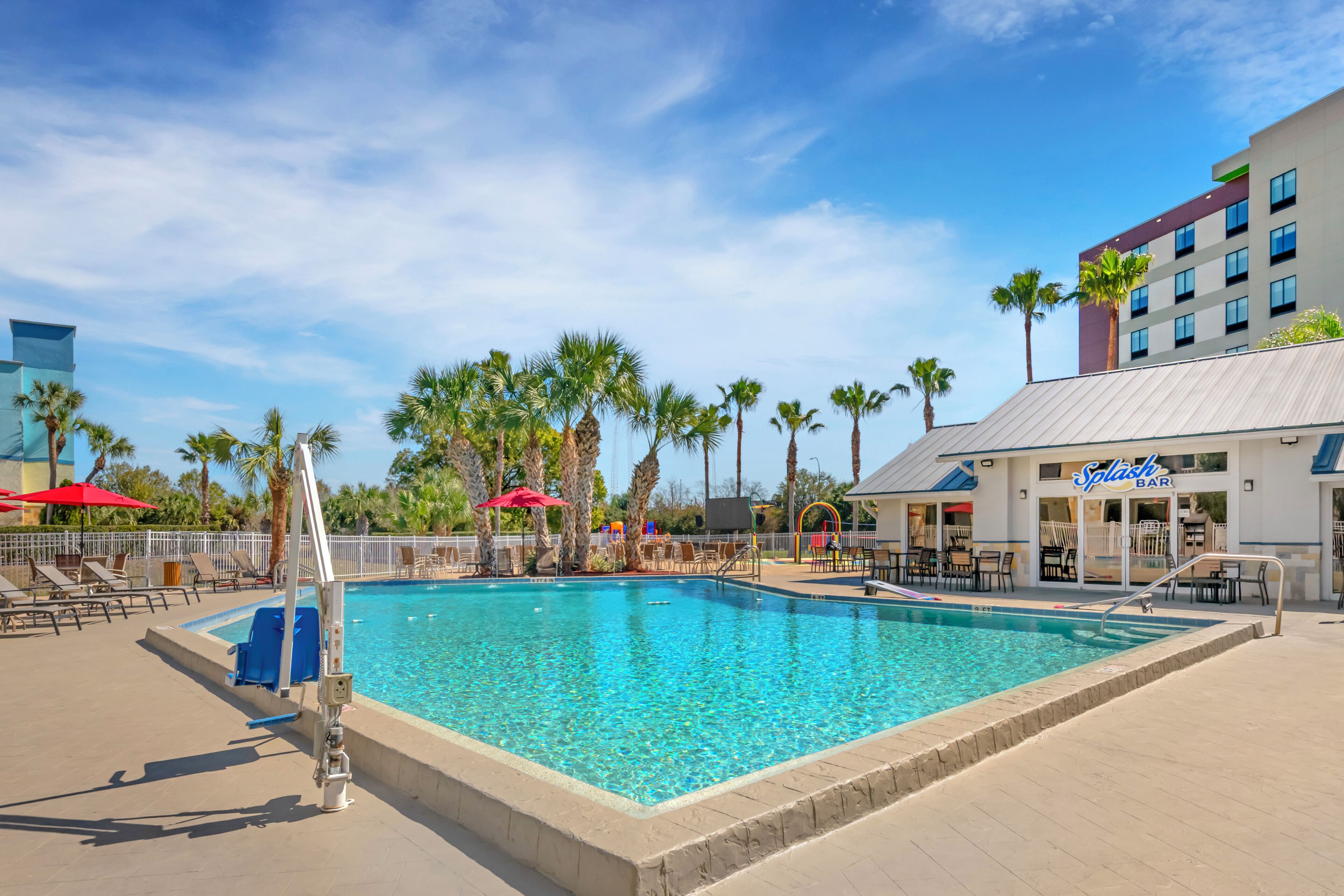 Una piscina al aire libre, sombrillas, sillones reclinables de piscina