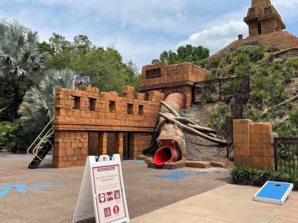 A brick structure with a slide and a signboard. - Disney's Coronado Springs Resort (Lake Buena Vista)