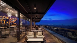 A rooftop lounge with seating and a view of the cityscape at dusk. - Disney's Coronado Springs Resort (Lake Buena Vista)
