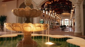 A grand fountain with multiple tiers and water spouts, set in a spacious lobby with high ceilings and arched columns. - Disney's Coronado Springs Resort (Lake Buena Vista)