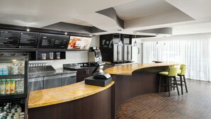 Una cocina moderna con una isla curva, electrodomésticos de acero inoxidable y una pizarra de menú.