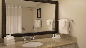 Un baño con un espejo grande, un lavabo y una cortina de ducha.