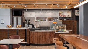 A modern cafe with a wooden counter, menu boards, and seating areas.