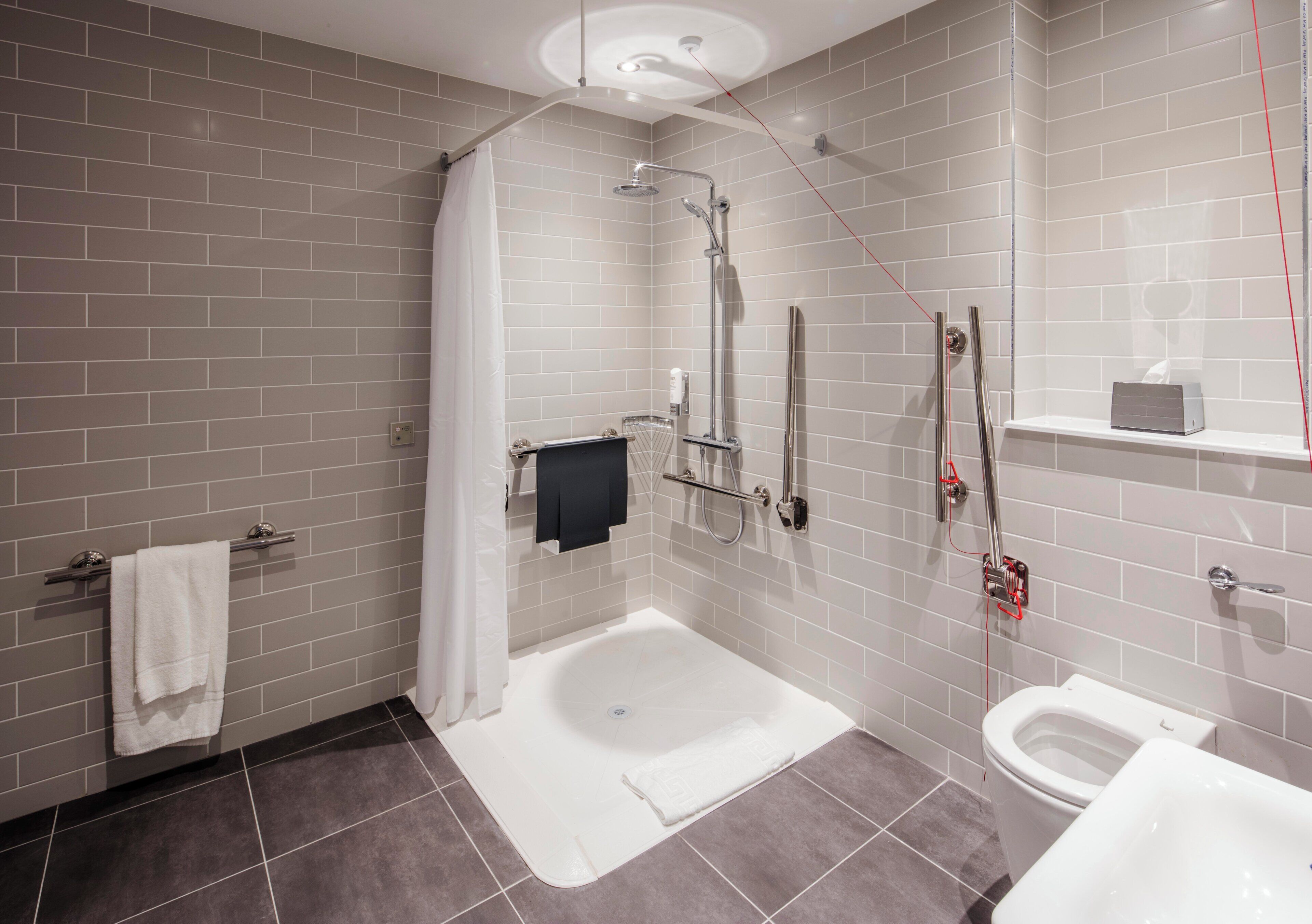 Une salle de bain moderne avec une douche à l’italienne, une baignoire et des toilettes.
