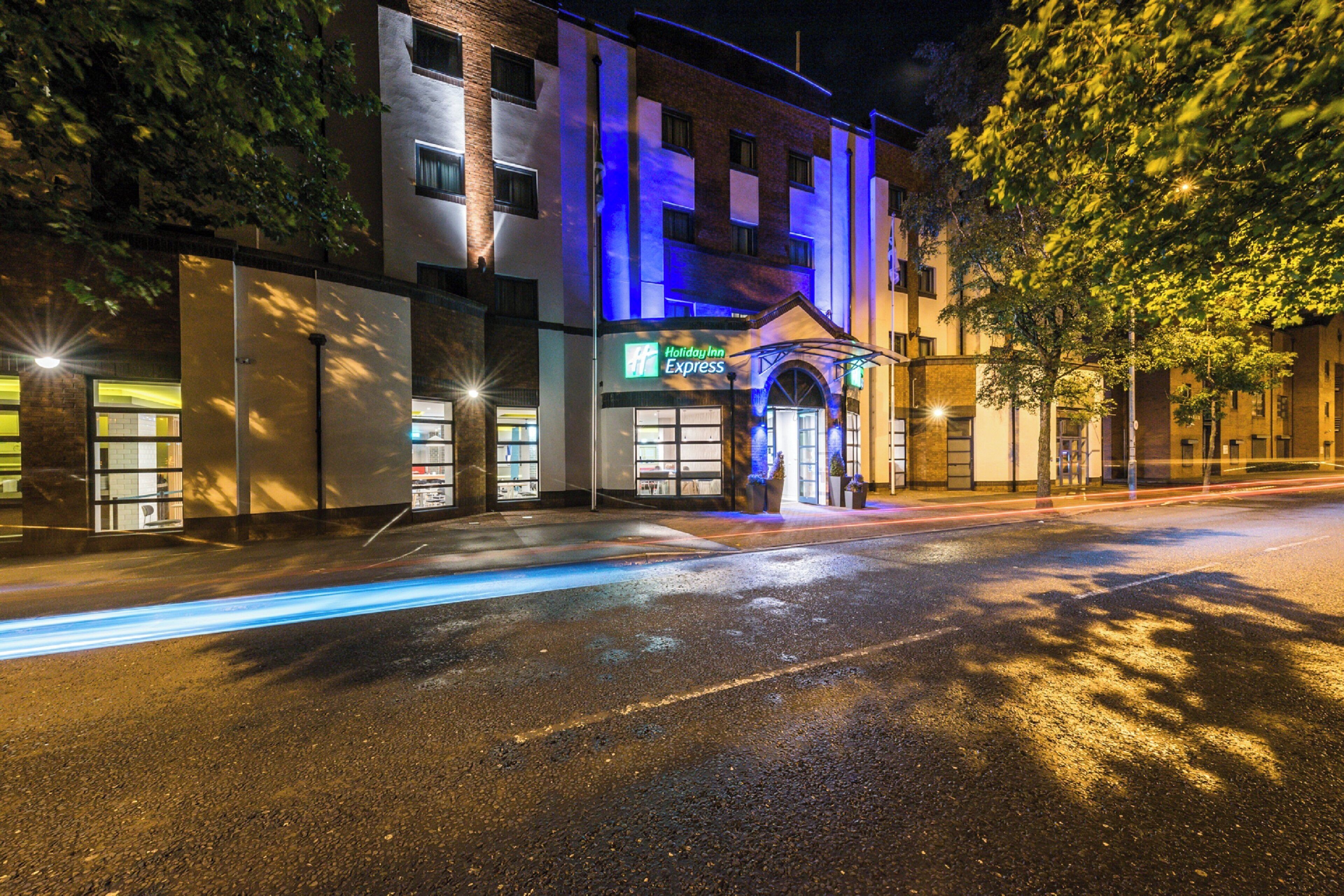 A Holiday Inn Express building with a modern facade, large windows, and a prominent entrance.