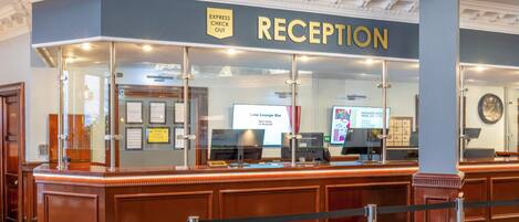 A reception area with a 'RECEPTION' sign, a 'Late Lounge Bar' sign, and a 'Packages Start From' sign.