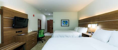 A hotel room with a bed, a desk with a computer, a TV, and a chair.