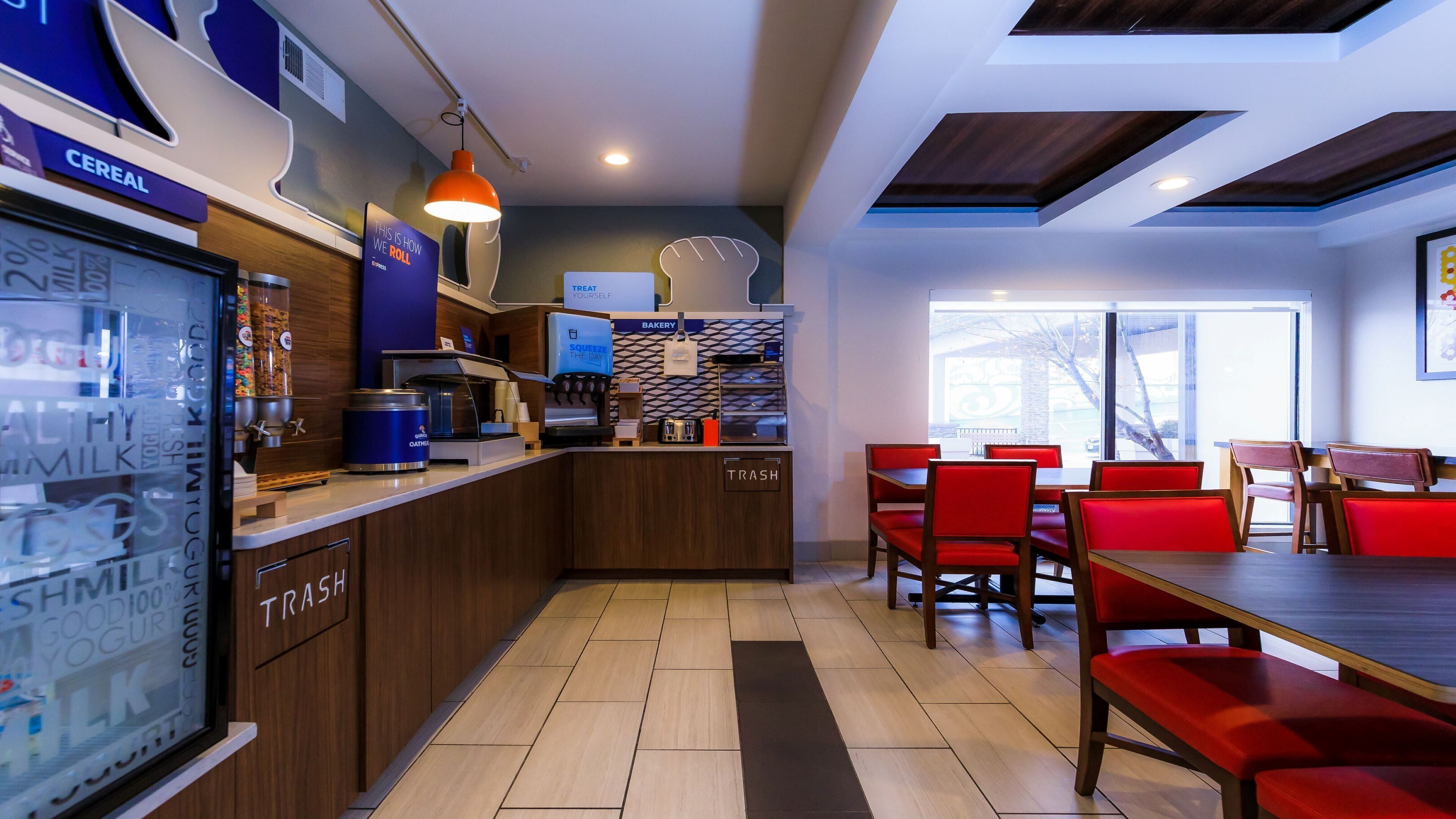 Un café moderno con mostrador, zona de estar y vistas al exterior.